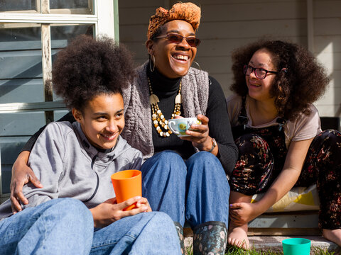 Mother with two daughters relaxing in backyard