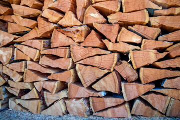 Natural texture of woodpile from coniferous trees. Pine firewood stacked on top of each other on a sunny day. Preparation of natural fuel. 