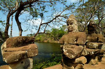 Fototapeta na wymiar Many Sculptures gods, spirits, demons on a bridge in South gate of Angkor Thom. Cambodia. Angkor Wat temple complex lake, river, Siem Reap