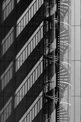 shadows of a spiral fire escape on a building