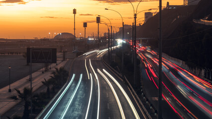 Moving lighs of cars along the road in sunset