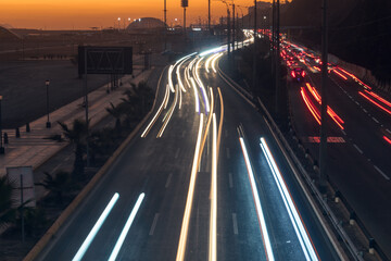 Obraz premium Moving lighs of cars along the road in sunset
