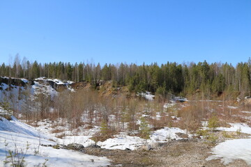 Quarry and rocks in Siberia. Stones, coniferous trees, snow and ice in a quarry in Siberia and the Urals.