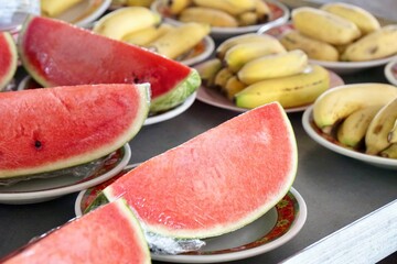 Group of fruits, watermelon slice and banana on plate preparing to offer food to the monks at noon. traditional and culture of Thailand. make merit at temple.