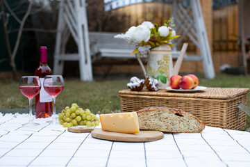 picnic in a clearing, cheese, drink, fruit. delicious food on a blanket. green grass, rest, weekend, lunch