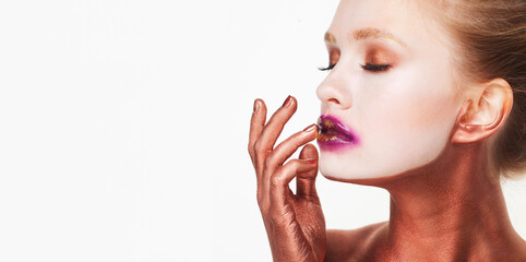 Beauty model female with bright fashion make-up touches face with fingers.
