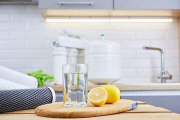 Glass of clean filtered water with lemon and ice in kitchen. Breakfast, fresh morning drink. Fresh drink on quarantine.