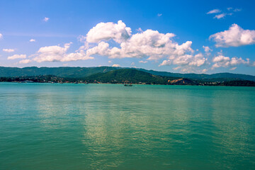 Blurred nature background of the morning sun by the sea, a beautiful golden light, among the trees, rocks and local fishing boats, the beauty of nature during the day.