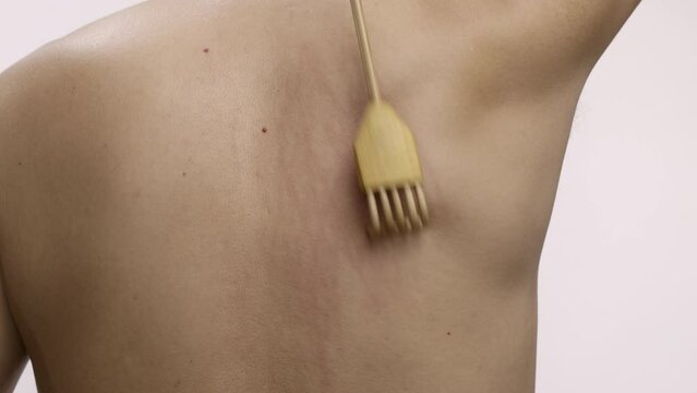 Senior man scratching his back with a back scratcher.