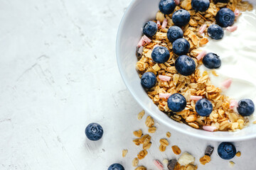 Yogurt with muesli and berries on a gray background.