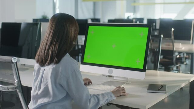 Business Woman Hands Working Internet on Computer On Desk. Girl Surfing on PC with Green Screen Notebook. Close Up Female Freelancer Searches For Information on The Internet