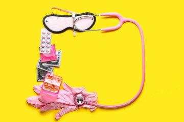 Frame made of pills, condoms, stethoscope, gloves and blindfold on yellow background
