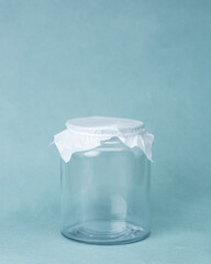 PUNE, INDIA - AUGUST 23, 2017: Isolated studio image of an empty glass jar on a blue background.