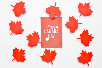 Maple leaves and paper card with text HAPPY CANADA DAY on white background