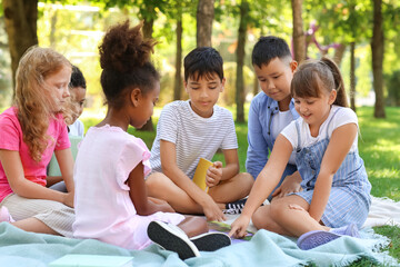 Little pupils reading book in park