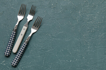 Different forks on grey background, top view