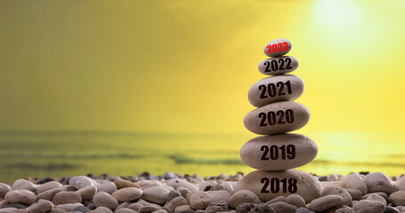 2023 new year is coming soon. New year 2023 begin. Years written on the stone tower. Year figures from 2018 to 2023. Sunset in the background