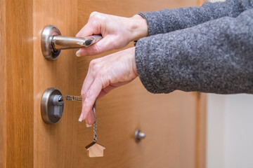 woman hands with key and door lock