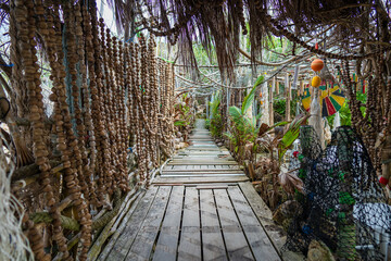 Wall of dried nuts along a wooden bridge on a tropical beach in paradise island Koh Phangan, Thailand