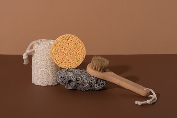 Eco-friendly bathroom accessories on a natural stone podium on a beige background. Beauty, sustainability and wellness concept