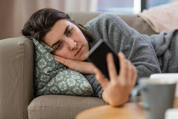 mental health, psychological help and depression concept - stressed woman with smartphone lying on...