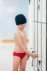 adorable elementary boy opening the locker room locker