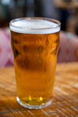 Fresh draught lager beer is glass served in indoor cafe