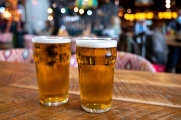 Fresh draught lager beer is glass served in indoor cafe