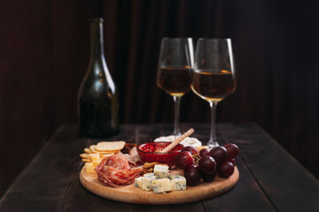 Wine appetizer. Sausage and cheese cut with fruit, cookies and sauce with two glasses of white port...