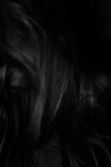 Naklejka premium Portrait of woman with hair covering her face, texture of female hair