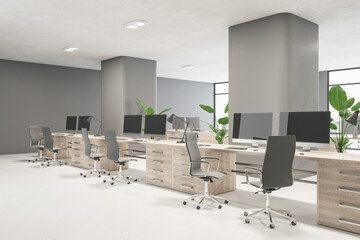 Clean wooden and concrete coworking office interior with empty computer screens, furniture, decorative plants and windows. Workplace and nobody concept. 3D Rendering.