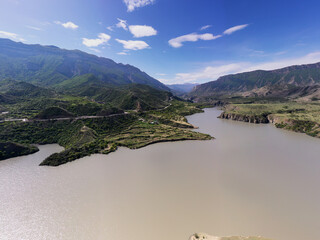 panoramic view of the Caucasus Mountains gorges ancient fortresses and curved mountain roads on a spring day taken from a drone