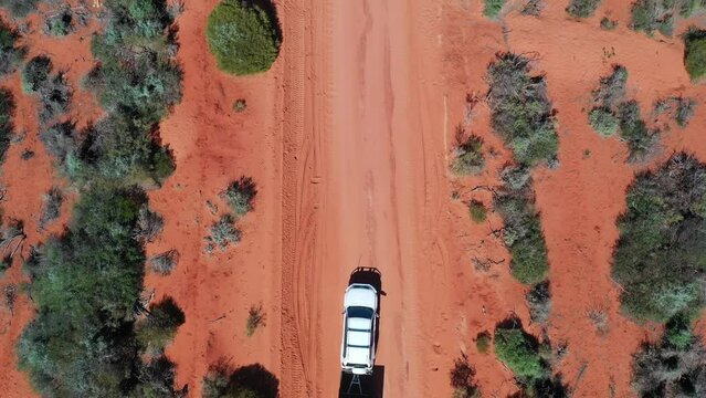 Aerial Landscape Drone View Of 4WD Vehicle Towing An Off Road Caravan Driving On A Sand Dirt Road At Peron Peninsula In Shark Bay, Western Australia.