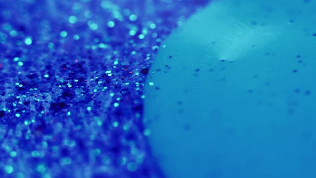 Glitter water. Ink bubble floating. Bokeh light. Blur blue color shiny sequin grain flow in transparent liquid abstract background.