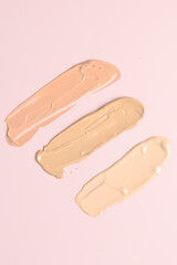 Makeup foundation smears on pink background. BB, CC cream foundation tonal smudge