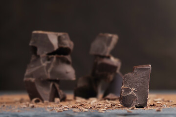 Broken dark chocolate and cocoa powder on a table