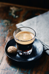 Coffee in glass cup on dark wooden background. Close up.