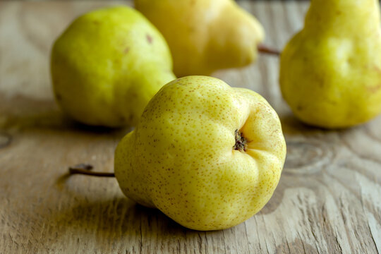 Juicy ripe organic yellow pears isolated on a rustic wooden table. Selective focus photo