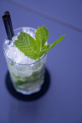 Green mojito cocktail with wide glass, lime, white rum and mint