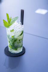 Green mojito cocktail with wide glass, lime, white rum and mint