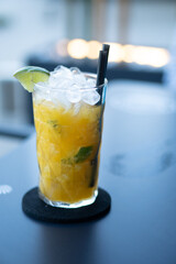 Mango caipiroska cocktail in a crystal glass, with vodka, lime and sugar