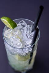 Brazilian caipirinha cocktail in a crystal glass, with cachaça, lime, ice and sugar