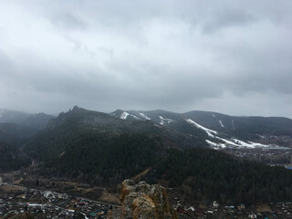 Coniferous forest and Mountain landscape. View of the mountains in the fog. Sunset over the mountains. The concept of recreation in the mountains.