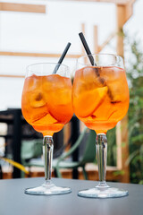 Two glasses of Aperol Spritz served on the terrace of modern bar. Popular Italian wine based...