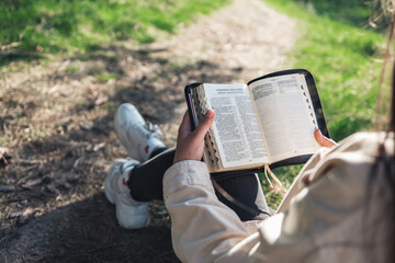 Fototapeta premium Girl with the Bible in nature. beautiful christian picture