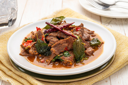 Spicy stir-fried beef slices with holy basil leaves, pad kra pao neua, a simple popular Thai food dish can be found throughout Thailand from street food carts to restaurants.