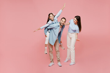 Full size young parents mom dad with child kid daughter teen girl in blue clothes give piggyback...