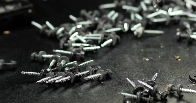 Close up of production Roofing screws, self-tapping screws on the table, industry background.