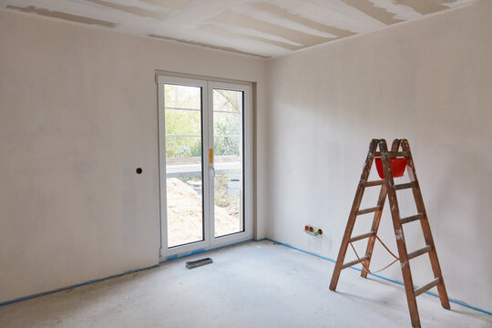 Leiter steht für Malerarbeiten an Wand im Raum bei Neubau
