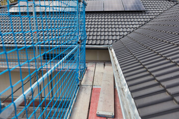 Baugerüst an Dach vom Haus auf Baustelle für Dachdecker